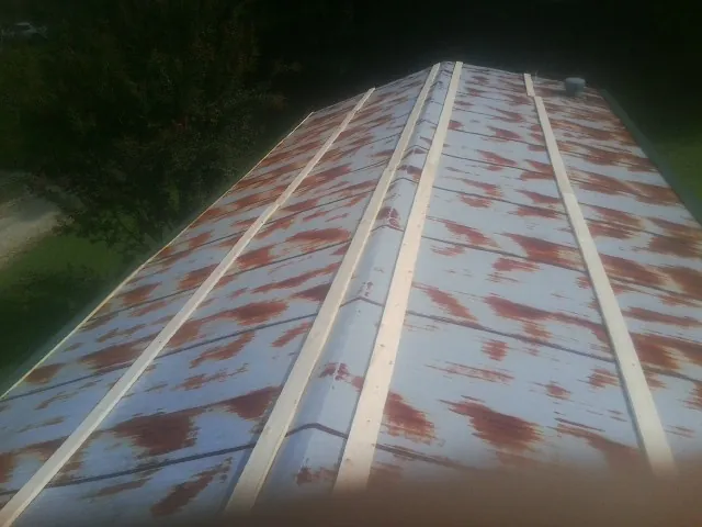 Rusted metal roof panels with new wood purlins before replacement — Storm Damage Roof Repair in East Liverpool by Roofing Brothers