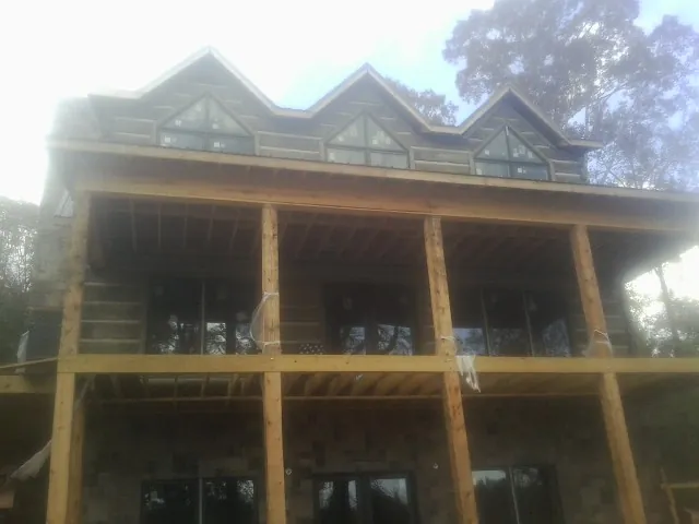Dormers and porch framing on a large log home under construction — Roof Coating work by our crew in East Liverpool