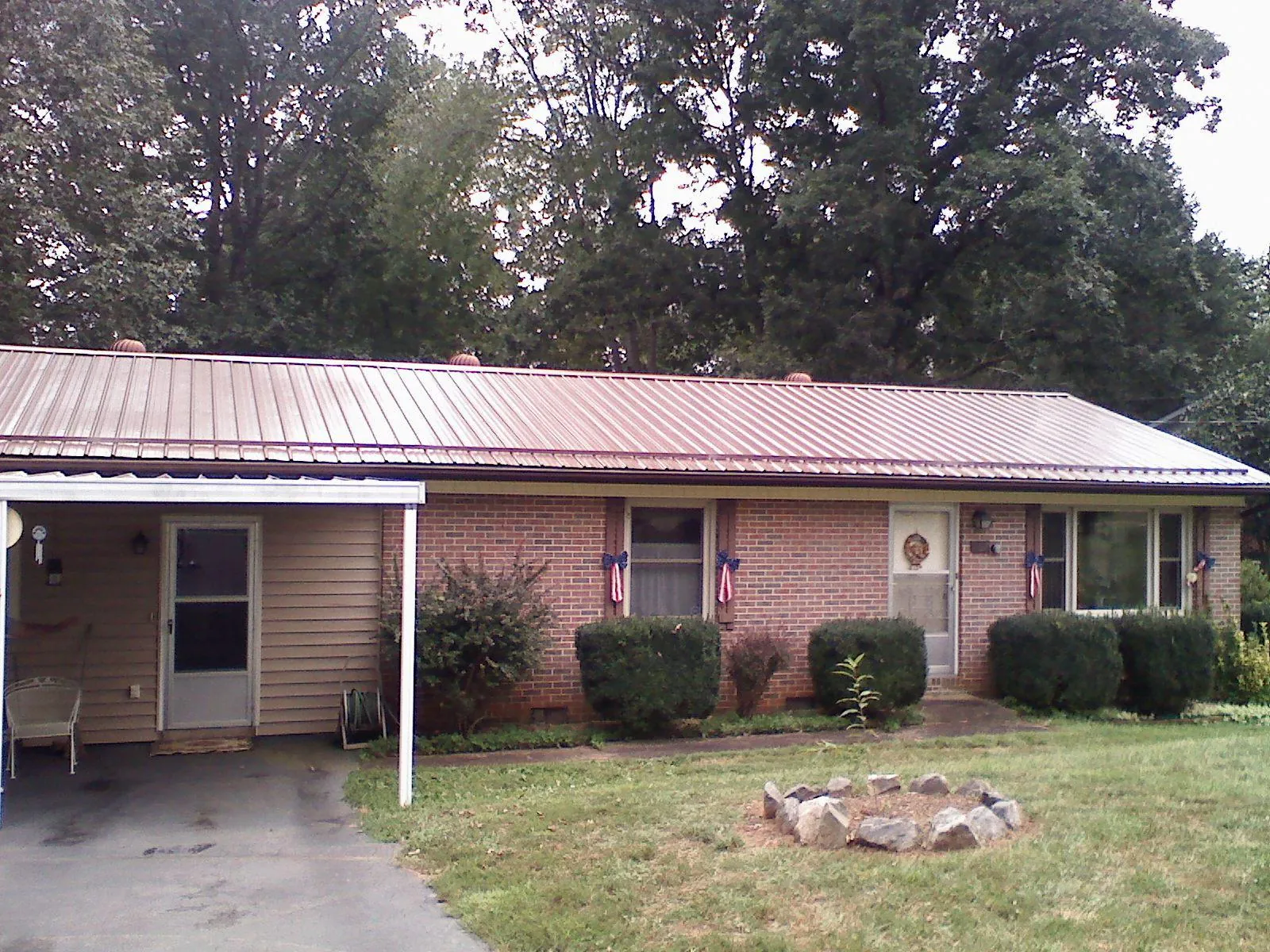 Bronze metal roof and carport on a brick ranch home — Roof Repair work by our crew in East Liverpool